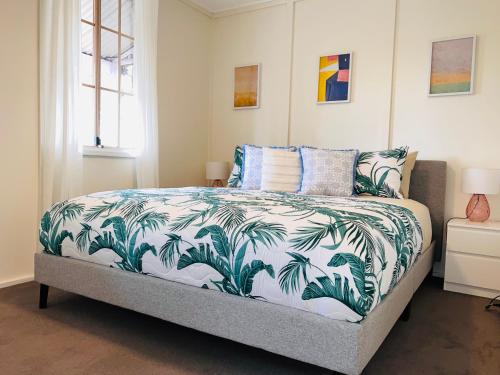 1 dormitorio con 1 cama con edredón azul y blanco en Katoomba Hideaway - Blue Mountains Modern Getaway, en Katoomba