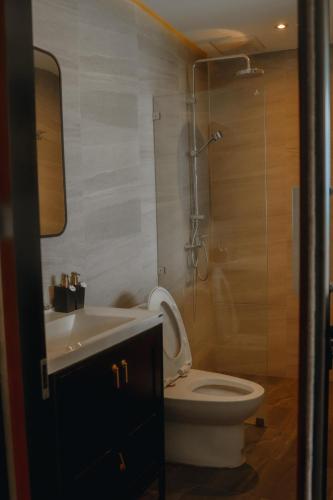 a bathroom with a toilet and a shower and a sink at The Sunnery Ville in Lom Kao