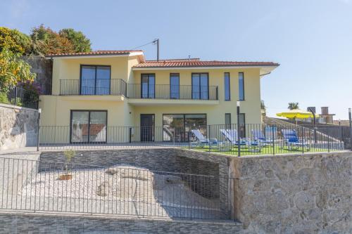 a large yellow house with blue chairs in front of it at Casa do Outeiro in Arcos de Valdevez