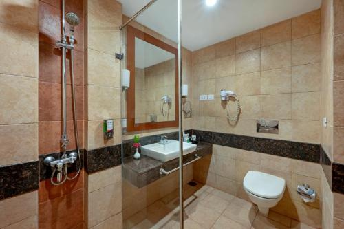 a bathroom with a toilet and a sink and a shower at Sterling Yercaud in Yercaud