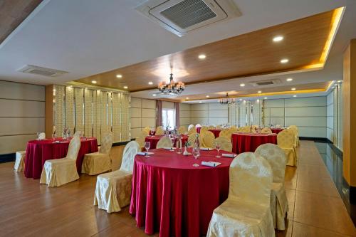 a banquet hall with red tables and white chairs at Sterling Yercaud in Yercaud