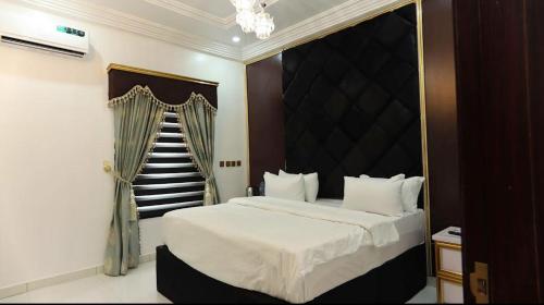 a bedroom with a large bed and a staircase at Kawruky Hotel Guobadia in Benin City