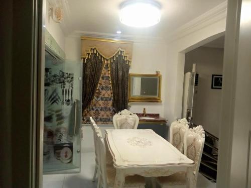 a dining room with a white table and chairs at Kawruky Hotel Guobadia in Benin City