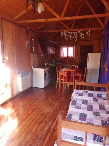 eine Küche und ein Esszimmer einer Hütte mit Holzböden in der Unterkunft Cabañas maiten in El Maitén