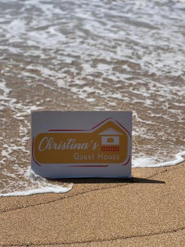 a guest house sign on the beach near the water at Christina's Guest House OFFICIAL in Little Corn Island