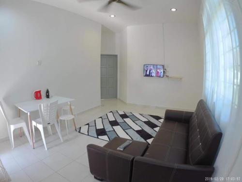 a living room with a couch and a table at Promenade Homestay 2 in Kampong Sura Masjid