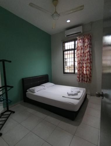 a bedroom with a bed in a green room at Promenade Homestay 2 in Kampong Sura Masjid