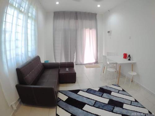 a living room with a brown couch and a table at Promenade Homestay 2 in Kampong Sura Masjid