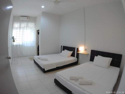 A bed or beds in a room at Promenade Homestay 2