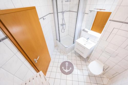 een badkamer met een douche, een toilet en een wastafel bij Meerstern in Juliusruh