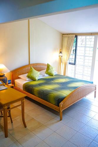 a bedroom with a large bed and a table at Hotel Deli River and Restaurant Omlandia in Medan