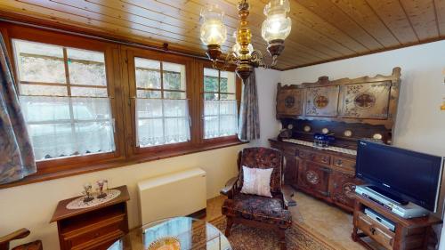 a living room with a tv and a glass table at Valentin VL1 in Naters