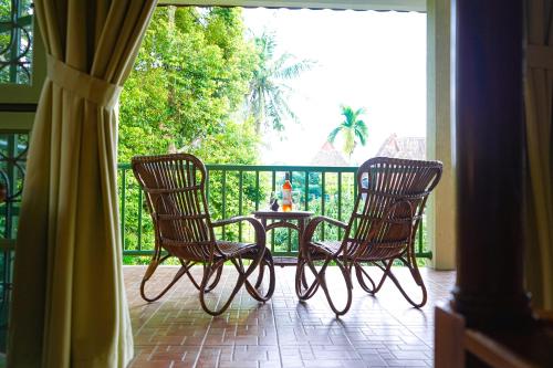 two chairs and a table on a porch at Hotel Deli River and Restaurant Omlandia in Medan