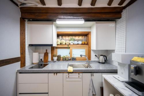 a kitchen with white cabinets and a sink at Hanok1942 in Daegu