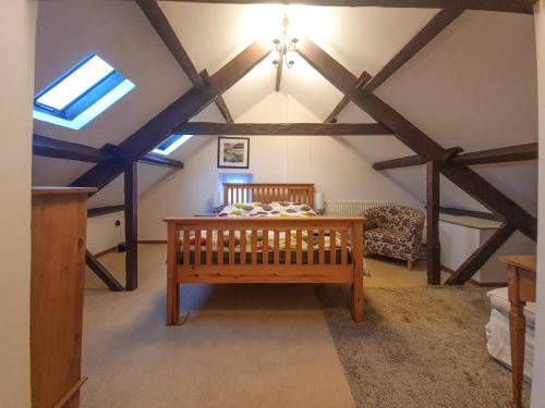 a room with a wooden crib in a attic at Syke Cottage in Mickleton