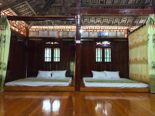 two beds in a room with wooden floors and windows at Duong Cong Chich Homestay in Lạng Sơn