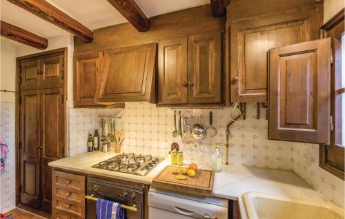 a kitchen with wooden cabinets and a stove top oven at Gorgeous Home In Begur With Kitchen in Begur