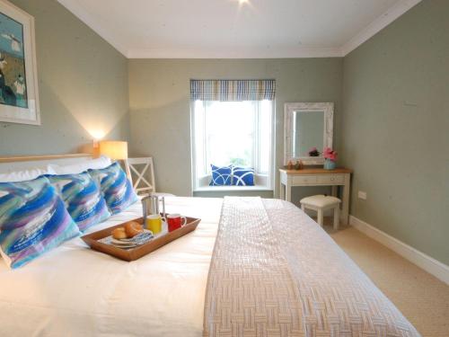 ein Schlafzimmer mit einem Bett und einem Tablett mit Essen drauf in der Unterkunft Crabbe Corner in Aldeburgh