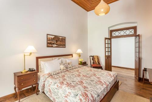 a bedroom with a bed and a table and a chair at W15 Lake Gregory in Nuwara Eliya