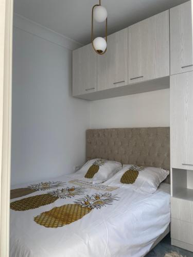 a bedroom with a large white bed with white walls at LA PETITE PERLE A MARSA PLAGE in La Marsa