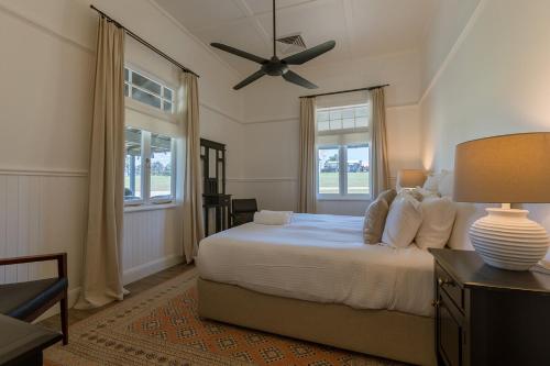 una camera da letto con un letto e un ventilatore a soffitto di The Homestead at Corunna Station a Belford