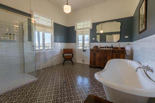 a bathroom with a tub and a shower and a sink at The Homestead at Corunna Station in Belford