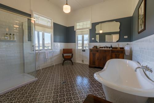 un bagno con vasca, doccia e lavandino di The Homestead at Corunna Station a Belford
