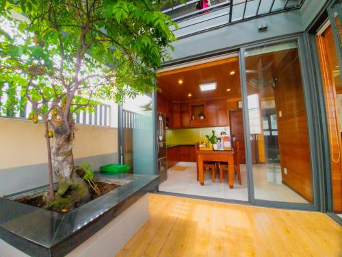 a house with a tree inside of it at LEHA Saigon Hotel Airport in Ho Chi Minh City