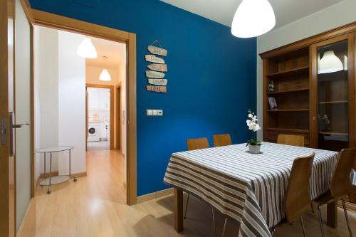 ein Esszimmer mit einer blauen Wand und einem Tisch mit Stühlen in der Unterkunft Apartamento Calle Concepcion Centro in Granada