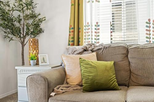 a couch with pillows on it in a living room at Caldwell Ruby Tuesday! 60's Inspired comfort 3B2B in Caldwell