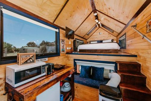 1 dormitorio en una casa pequeña con una ventana grande en Tiny Truck at Ithaca - Mudgee's Most Unique Stay, en Stony Creek