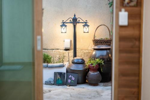 a doorway with two large pots and a street light at Hanok1942 in Daegu