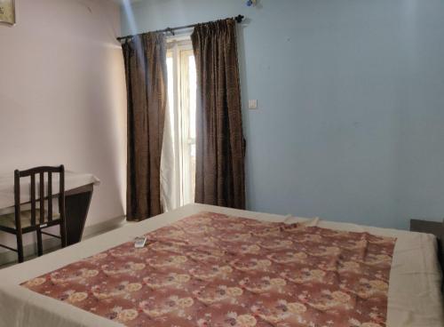 una camera con un letto e una finestra con un tappeto di Satvik Stays a Puri