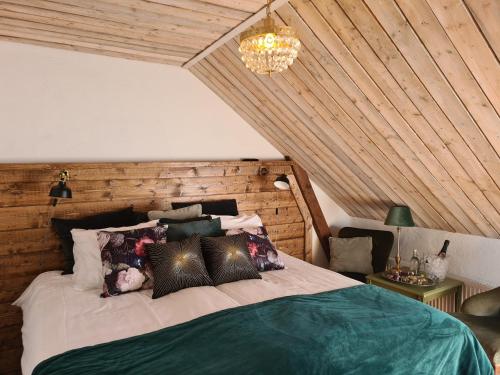 a bedroom with a large bed with a wooden wall at Lanthotell Lögnäs Gård in Laholm