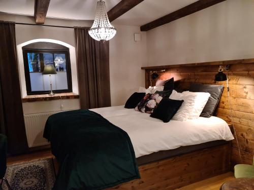 a bedroom with a large bed with white sheets and pillows at Hotell & Spa Lögnäs Gård in Laholm