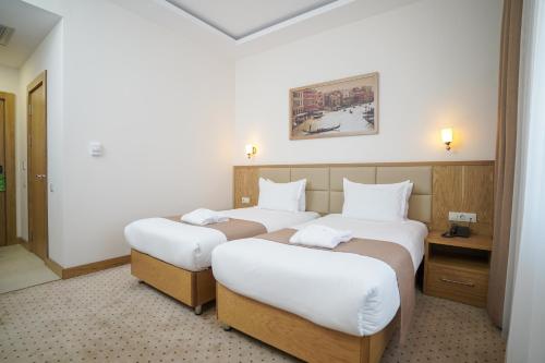 Ліжко або ліжка в номері Milan Hotel