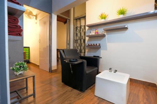 a salon with a black chair and a white sink at The Blossom Resort - Chikmagalur in Chikmagalūr