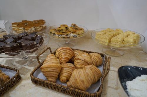 タシュケントにあるMilan Hotelのペストリーやデザートのトレイがいくつか置かれたテーブル