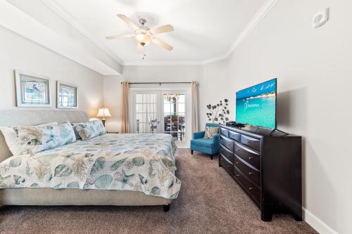 1 dormitorio con 1 cama y TV de pantalla plana en The Oasis at Orange Beach 2203, en Orange Beach