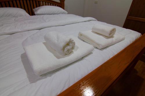 a bed with white towels on top of it at บ้านสวนมะม่วงรีสอร์ท 