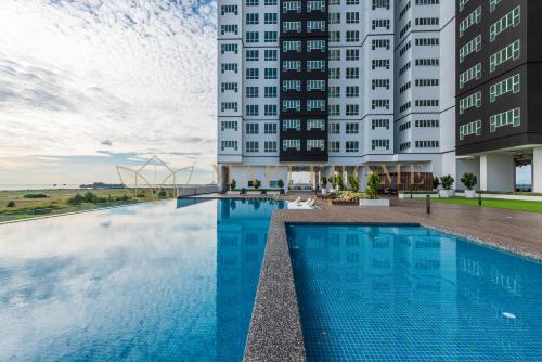 a hotel swimming pool in front of two tall buildings at Amber Cove Premier Suites Melaka in Melaka