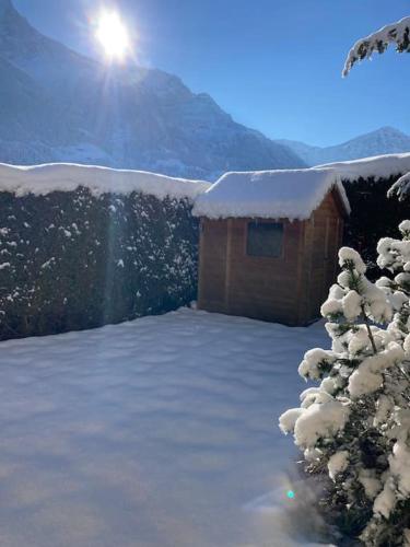 a snow covered cabin with the sun in the background at Chalet Cocoon in Val dʼIlliez