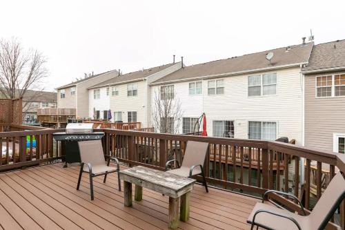 a deck with a picnic table and chairs and a grill at Beautiful Townhome in Sterling