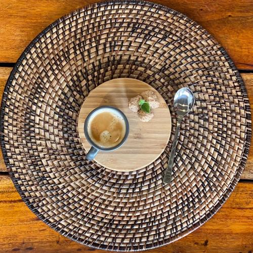 a plate with a cup of coffee and a spoon at Bathala Resort in Panglao