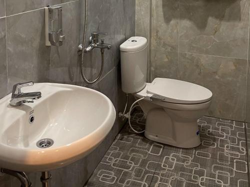 uma casa de banho com um lavatório, um WC e um chuveiro em RedDoorz Plus near Alun Alun Kota Bora em Blora