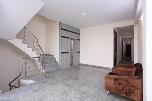 a living room with two chairs and a staircase at OYO Dlf Cyber City Near Aravali Biodiversity Park in Gurgaon