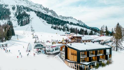 a ski lodge in the snow with a ski slope at Sport Hotel Passo Carezza in Vigo di Fassa