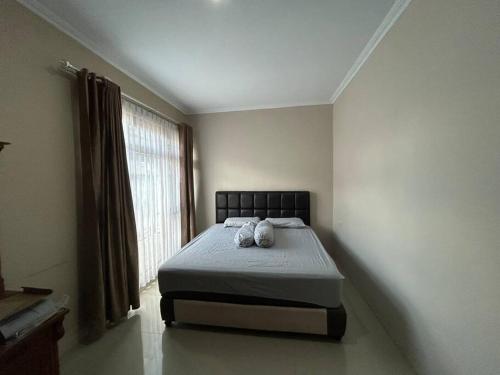 - une chambre avec un lit avec deux animaux rembourrés dans l'établissement Guest House DiFi Timoho, à Demangan