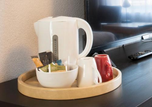 uma bandeja com uma cafeteira e chávenas numa mesa em Hotel Mayflower em Leiden