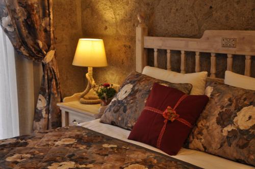 a bedroom with a bed and a lamp on a table at Assos Sunaba Kasri Hotel in Behramkale